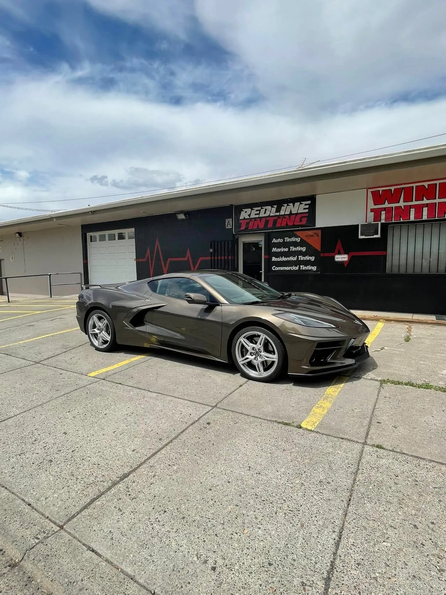 Bronze Corvette C8 front three-quarter view outside the Redline Tinting storefront in Yakima