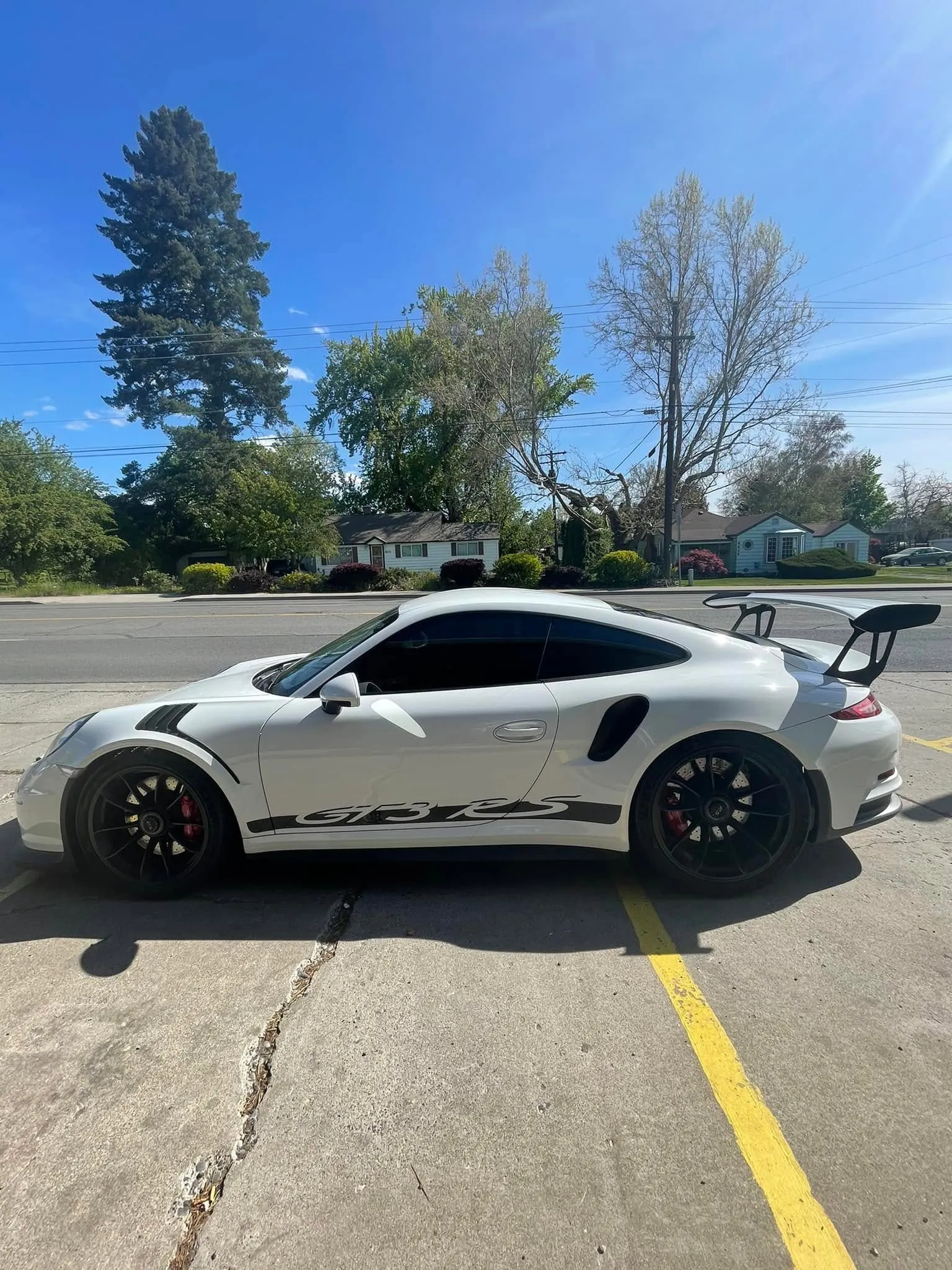 White Porsche 911 GT3 RS with black side stripes and freshly tinted windows parked outside the Redline Tinting shop in Yakima